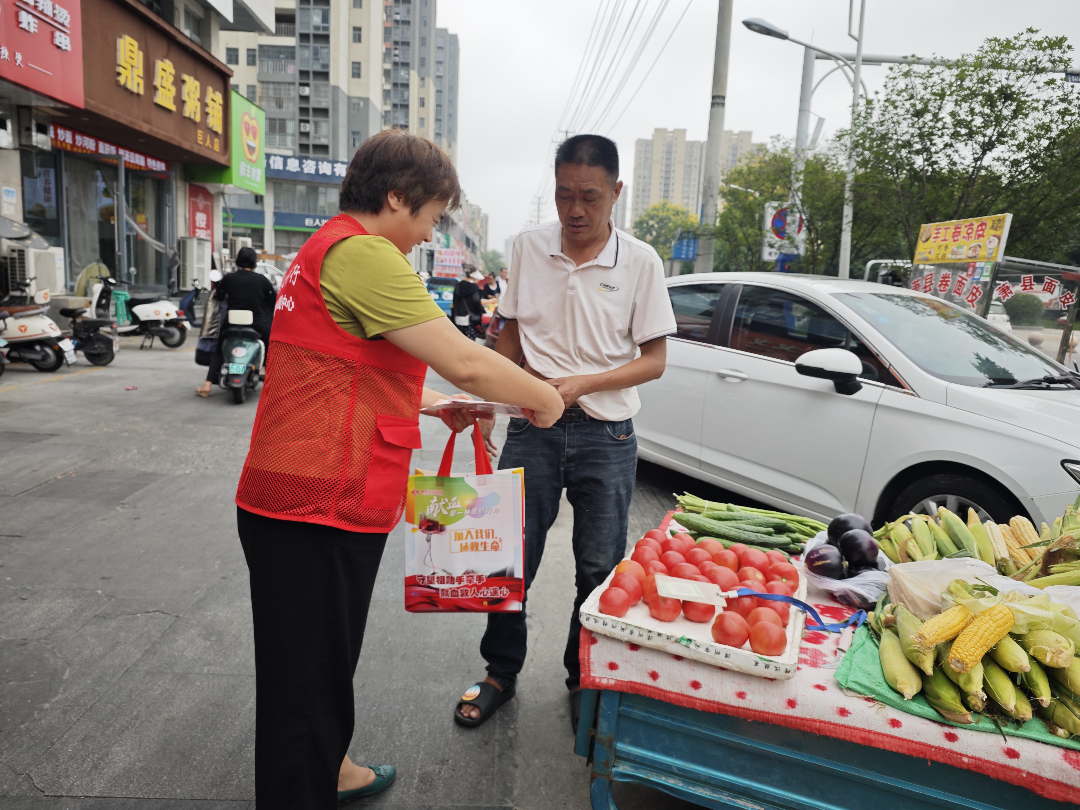 9志愿者向市民发宣传单.jpg